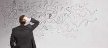 Pensive Businessman With Abstract Arrows Sketch On Concrete Wall Background. Confusion And Direction Concept.
