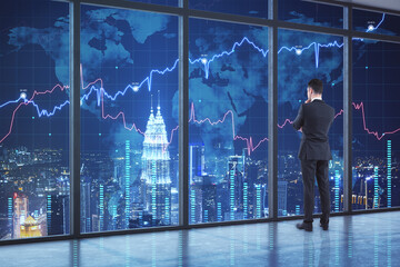 Poster - Businessman standing in modern office interior with forex chart and night city view. Occupation and trade concept.