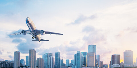 Fototapete - Airplane on beautiful city skyline and blue sky background. Travel, mockup, and aviation concept.