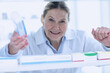 © Qwenergy - Pharmacist is working. Woman wearing special medical uniform. A woman looks through apathetic shelves and shows a package of medicines