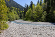 Wunderschöner Gebirgsfluss in den Alpen mit Panorama und kleinen Wasserfällen
