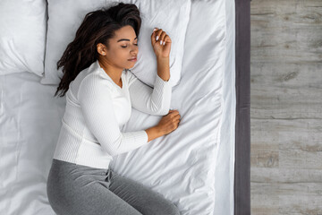 Portrait of young African American female sleeping in bed