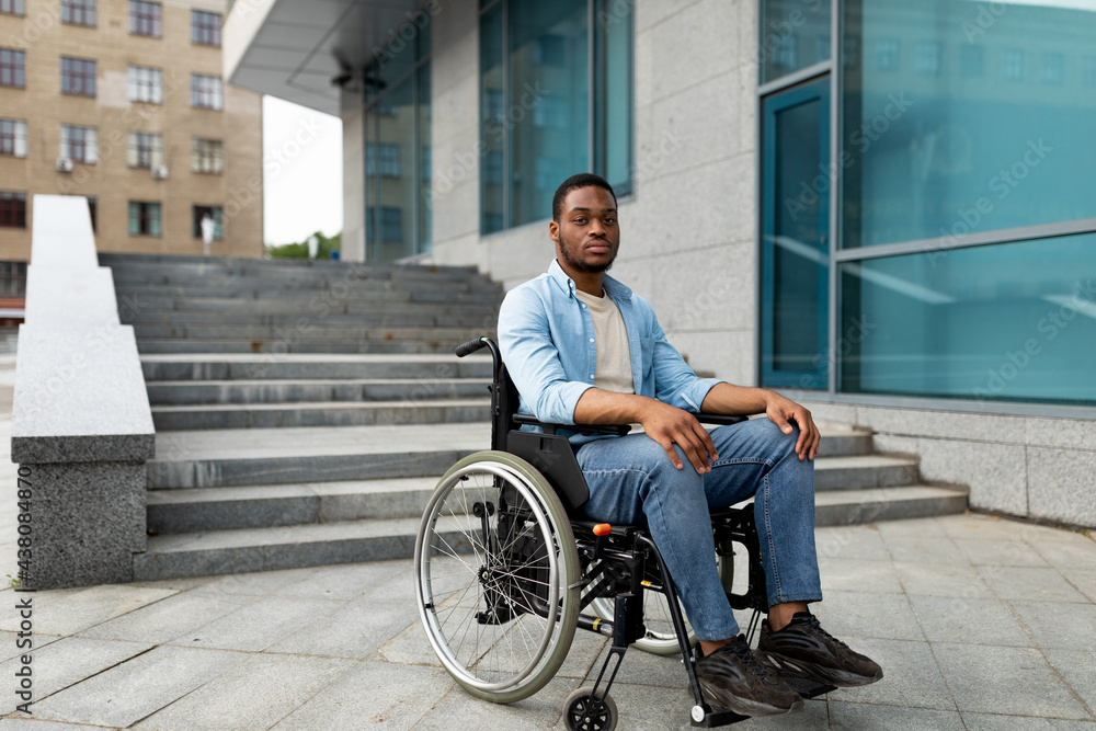 Portrait of unhappy black impaired man in wheelchair next to siatrs without ramp, feeling stressed, free space - obrazy, fototapety, plakaty 