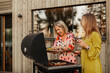 © Johnér - Smiling female friends preparing food on barbecue