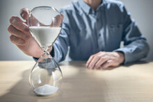 Business Man Holding Hourglass Timer, Time Slipping Away For Important Schedule And Deadline