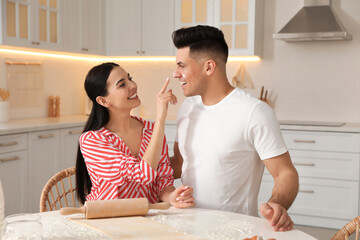 Poster - Happy couple wearing pyjamas and cooking together in kitchen