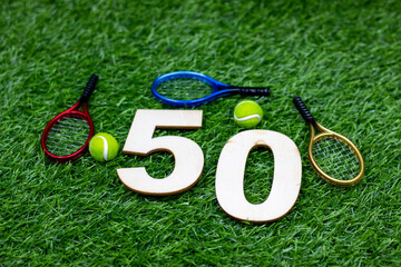 Wall Mural - Tennis 50th Birthday Anniversary  with ball and racket on green grass 