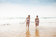 © ADDICTIVE STOCK - Ladies standing in sea near sandy coast