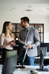 Wall Mural - Colleagues in office. Businesswoman and businessman discussing work in office. Two friends working together.