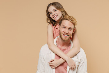 Wall Mural - Young happy parent man have fun with cute child teen girl in casual pastel clothes Daddy little kid daughter look camera hug stand behind isolated on beige background Father's Day Love family concept