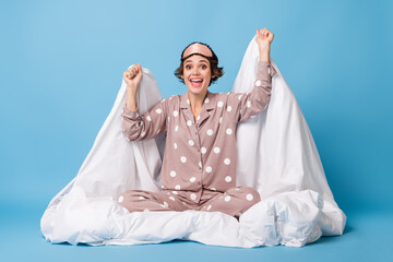 Poster - Full size photo of young excited girl happy positive smile celebrate victory success sit duvet isolated over blue color background