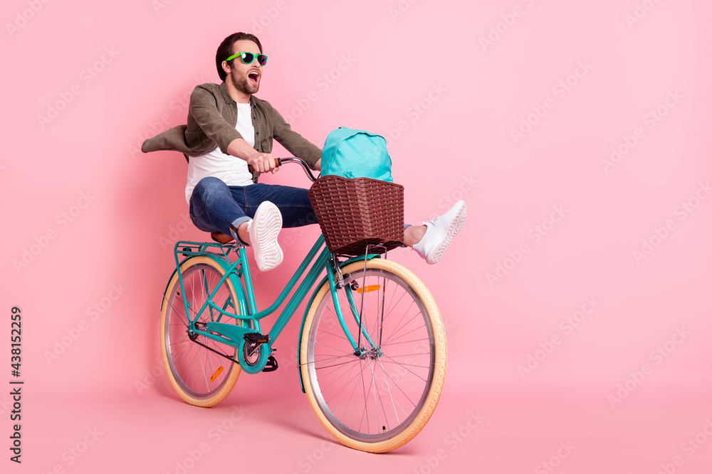 Photo of sweet cute guy dressed brown shirt dark eyeglasses riding bike backpack looking empty space isolated pink color background - obrazy, fototapety, plakaty 