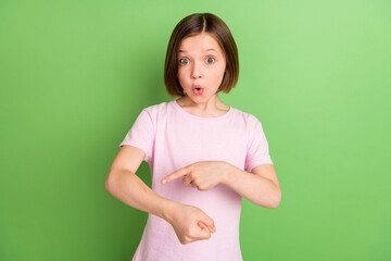 photo of young little girl amazed shocked surprised point finger hand scar isolated over green color