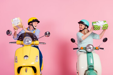 Poster - Photo of excited charming senior husband wife driving motorbike dressed helmets holding present boxes isolated pink color background