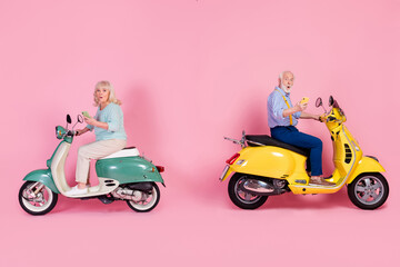 Poster - Full size profile side photo of two shocked mature male female moped rider driver grey hair use phone isolated on pink color background