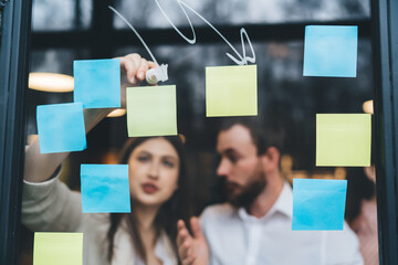 Poster - Blurred colleagues arranging papers on glass