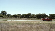 Old Red Pickup Truck On A Rural Road In Argentina. Side Angle View. 4K.