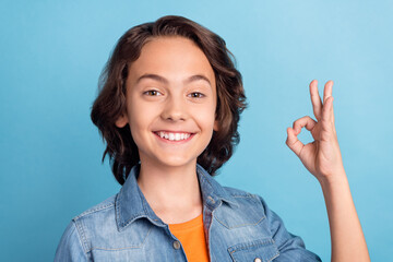 Sticker - Photo of young preteen boy happy positive smile show okay sign choice great promo isolated over blue color background