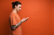 © Drobot Dean - Young white man with tattoo smiling while using cellphone