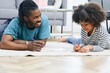 © Peakstock - Dad and daughter drawing pictures together at house floor. Father's day, father-daughter relationship