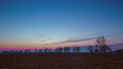 Wall Mural - Evening sky over plowed field in time lapse.