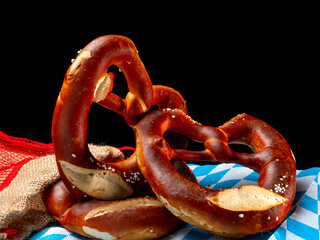 Wall Mural - Three freshly baked pretzels and arranged on a black background.Traditional Bavarian food