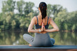Young woman doing yoga outdoors in a beautiful spot on a riverside