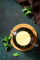 Wall Mural - Therapeutic herbal tea. Hot mint tea on a dark  stone or concrete background. Top view, flat lay background. Copy space.