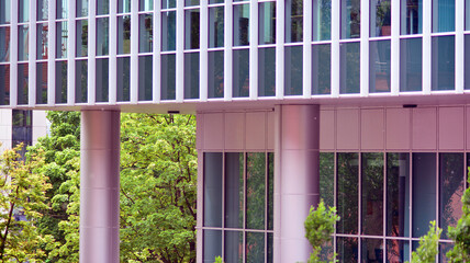 Abstract closeup of the glass-clad facade of a modern building covered in reflective plate glass. Architecture abstract background. Glass wall and facade detail.