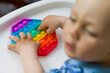 © оксана савоськина - baby playing with colorful toy pop it