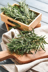 Composition with fresh rosemary on dark wooden background