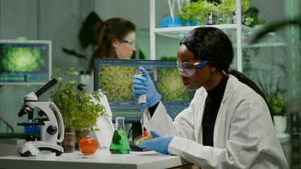 biologist scientist african woman researcher taking genetic solution from test tube with micropipett
