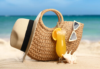 Beach accessories with glass of cocktail on sand at tropical resort