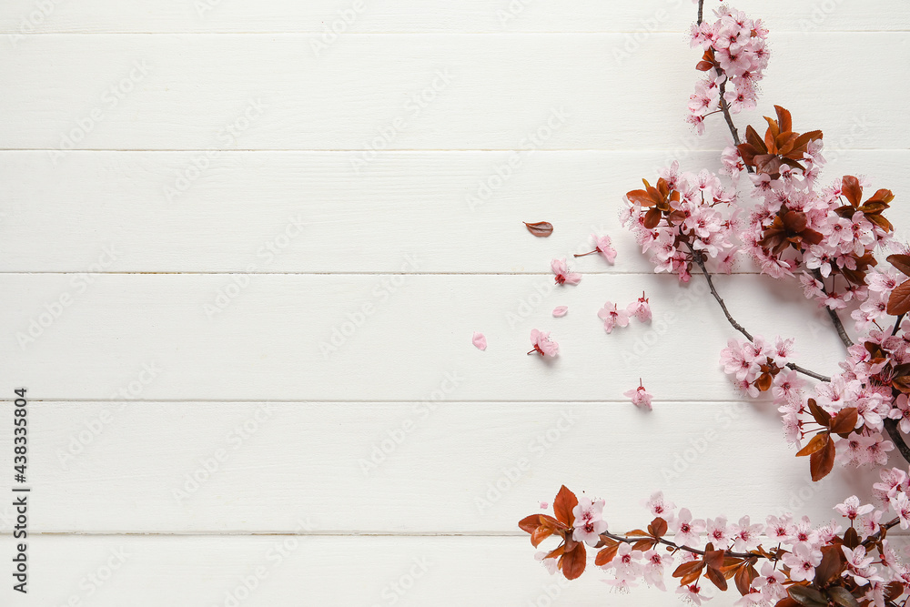 Beautiful blossoming branches on white wooden background