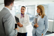 © Nebojsa - A group of business people stand in the hallway while waiting for the meeting to begin.