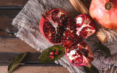 Wall Mural - red pomegranate on a napkin on a dark wood background top view