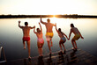 © Zoran Zeremski - Young friends having fun enjoying a summer day swimming and jumping at the lake.