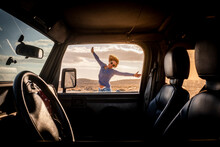 Happy Woman In Travel Adventure Lifestyle Summer Vacation Jump With Hoyful And Smile Outside The Car Viewed From Inside Through The Door - Concept Of Road Trip And Female Driver - Freedom Journey Life