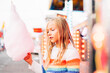 © ADDICTIVE STOCK - Little girl has fun at the fair with lights and eats sweet cotton.