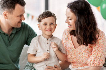 Wall Mural - family, holidays and people concept - portrait of happy mother, father and little son at home party