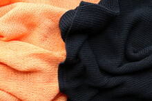 A Close Look At The Texture Of A Black And Orange Knitted Clothes