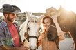 © DisobeyArt - Farmer couple having fun with bitless horses during sunny day inside ranch corral - Main focus on right horse