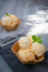 Wall Mural - Ice cream scoops with vanilla ice cream in a bowl with mint. Vertical photo