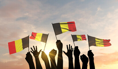 Wall Mural - Silhouette of arms raised waving a Belgium flag with pride. 3D Rendering