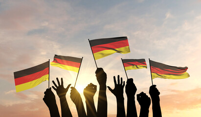 Wall Mural - Silhouette of arms raised waving a Germany flag with pride. 3D Rendering