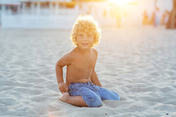 Wall Mural - Portrait of a boy at sunset by the sea