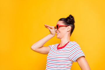 Wall Mural - Photo of charming pretty young lady wear striped t-shirt dark eyewear dancing looking empty space isolated yellow color background