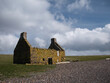 An abandoned, derelict croft or farm house on a pebble beach at Stenness, Northmavine in  Shetland, Scotland, UK