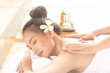 Beautiful asian woman lying massage treatment with happy mood on vacation day.Wellness body care and spa aromatheraphy concept.