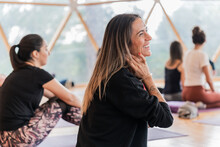Cheerful Woman Touching Neck And Looking Away During Practicing Yoga